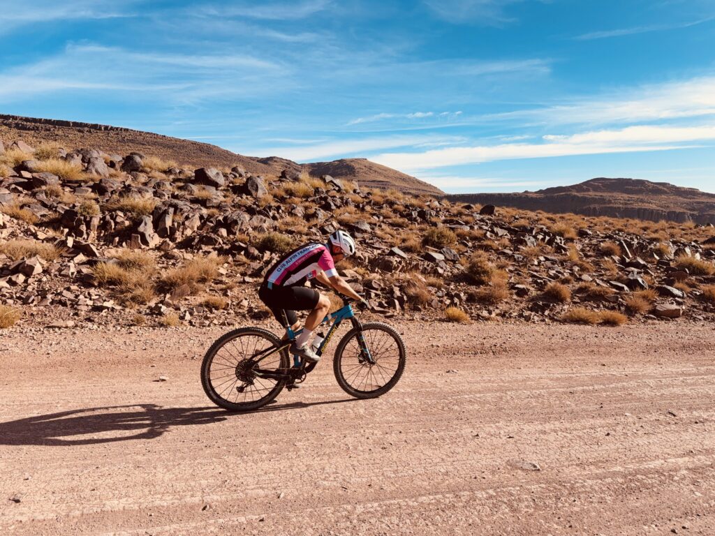 Cyclists riding through the High Atlas Mountains on a multi-day cycling tour from Marrakech to Ouarzazate, passing valleys, kasbahs, and scenic desert landscapes - High Atlas cycling tour