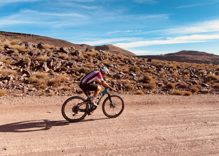 Cyclists riding through the High Atlas Mountains on a multi-day cycling tour from Marrakech to Ouarzazate, passing valleys, kasbahs, and scenic desert landscapes - High Atlas cycling tour